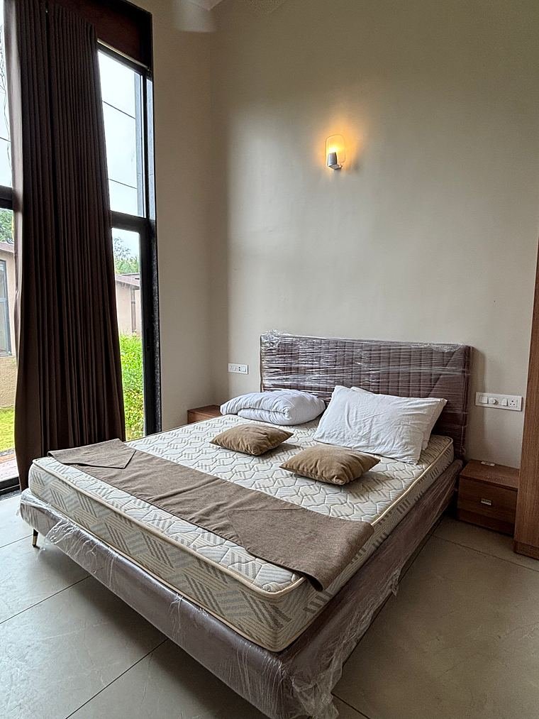 Bedroom with an upholstered headboard bed and bedside drawers by the tall windows - Iskon Valukad - Cottage Interiors by Bosk Furniture