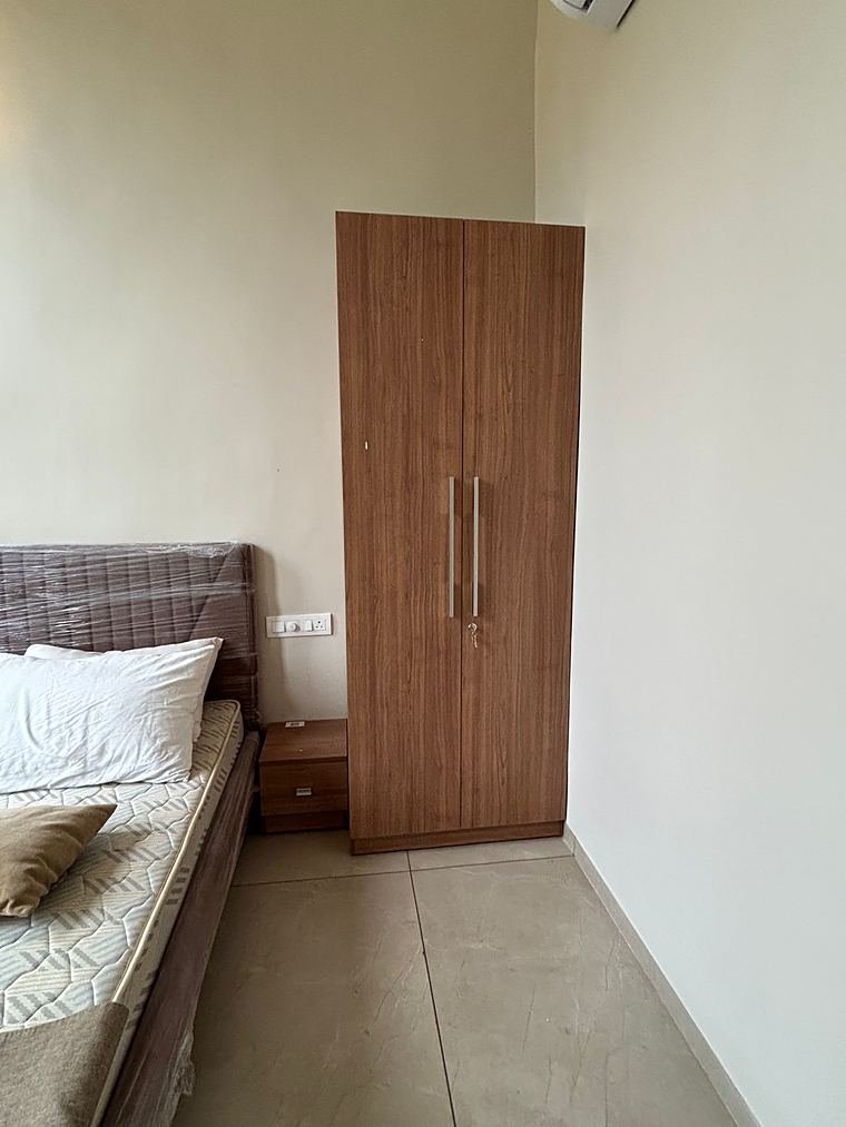 Two-door walnut wardrobe with long bar handles beside the bed - Iskon Valukad - Cottage Interiors by Bosk Furniture